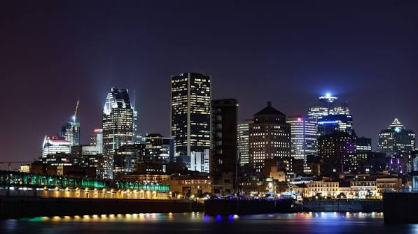 Montreal skyline at night with illuminated downtown towers reflected on the river